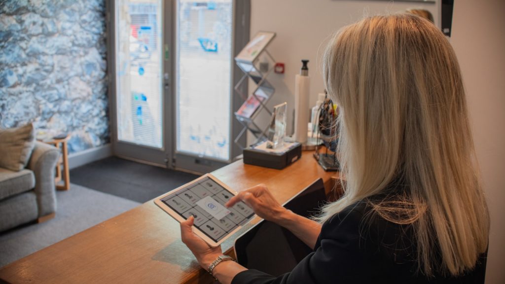 Woman using a tablet at a reception desk.