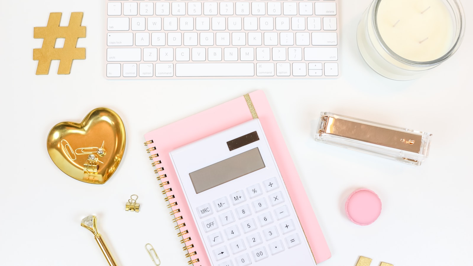 pink and white calculator beside silver and gold key